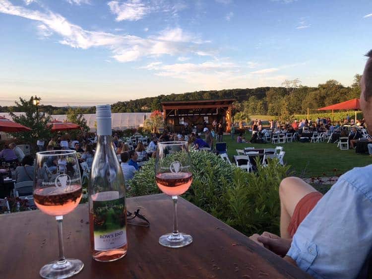 Beneduce Vineyards outdoor winery view with a bottle and two glasses of light pink wine
