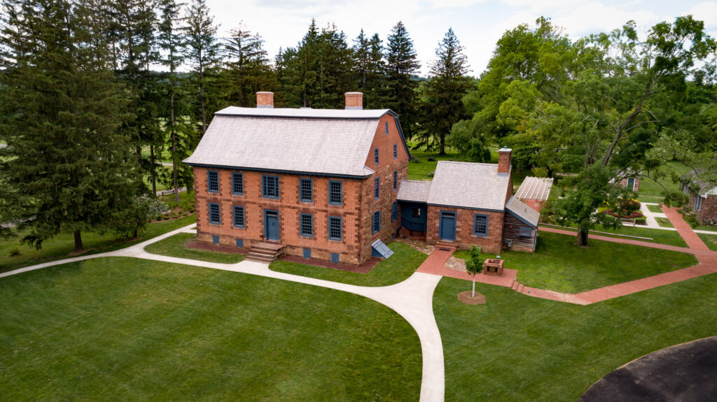 Red brick two-story mansion with small attached building.