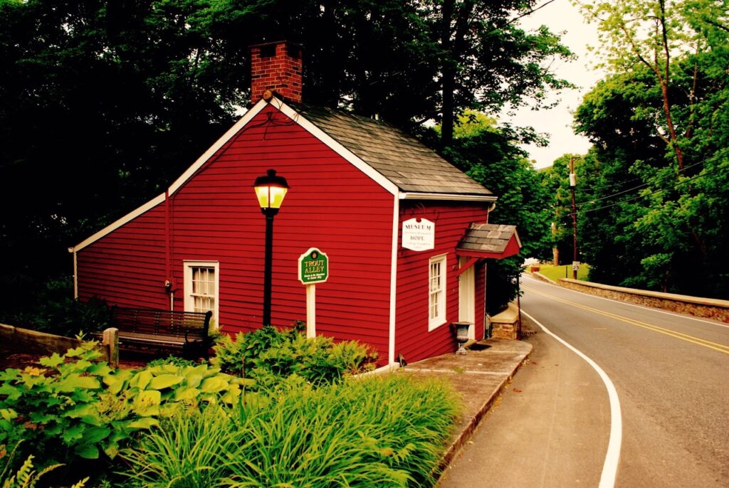 Small read historic home turned museum on a two lane road.