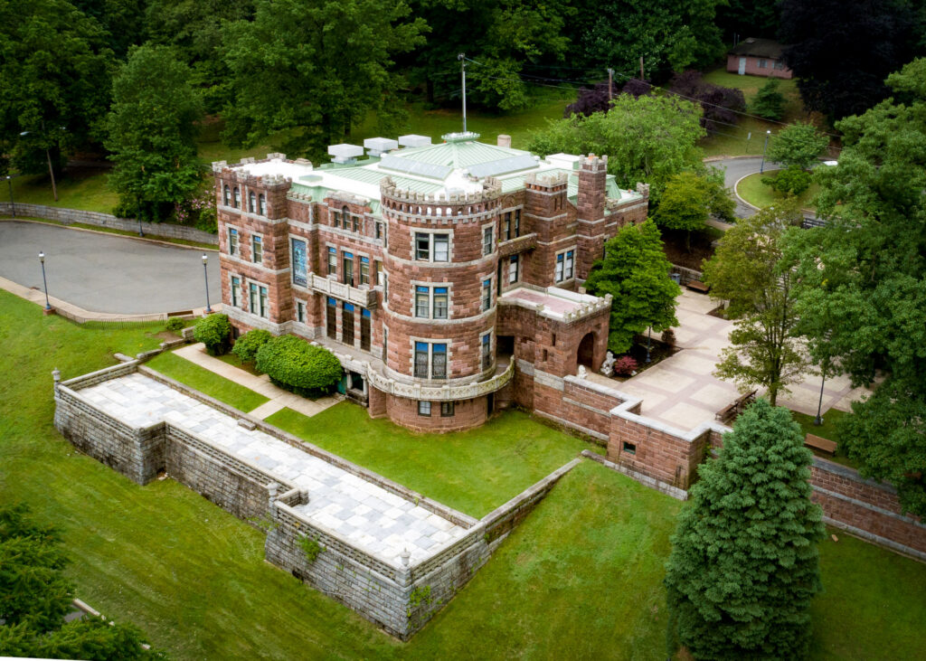 Historic large brick castle with partially exposure perimeter wall.