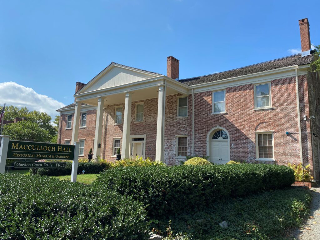 Macculloch Hall Museum with a sign in front of two story historic brick manor with white columns