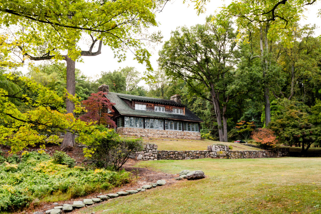 Long exterior shot of the Stickely Museum set in a historic wood-shingled home with paned windows across the front.