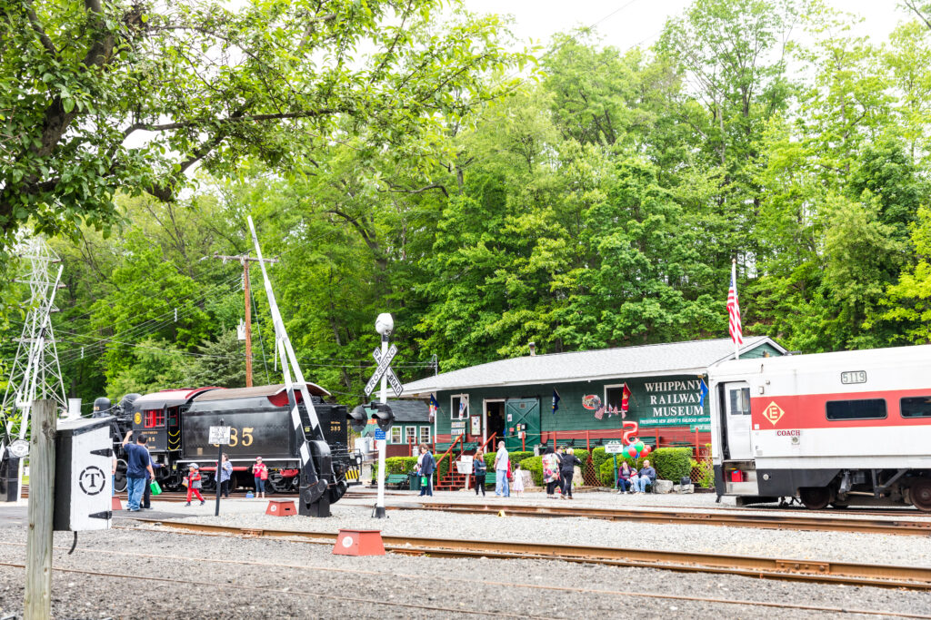Two trains from different eras sit on tracks in front of the museum.